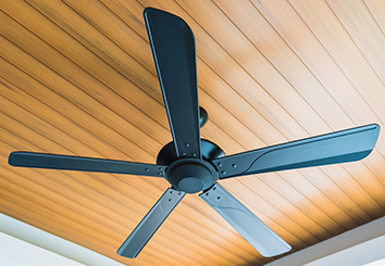 Black ceiling fan with wood panel ceiling.