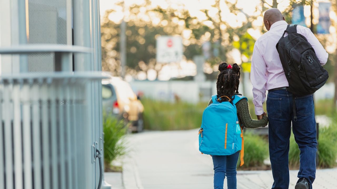 father and daughter walking on a city street