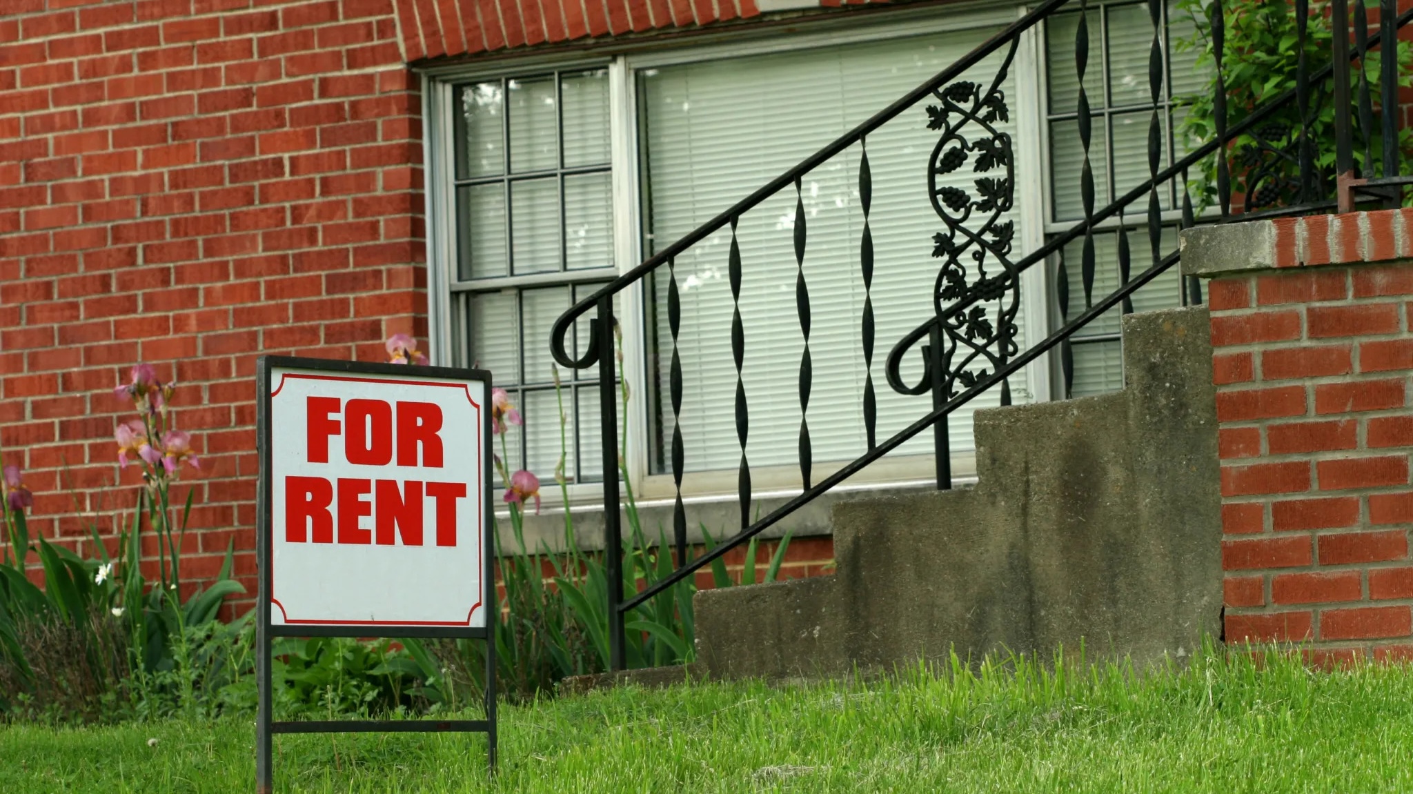 house with a for rent sign in front of it