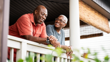 couple standing on the porch of their home