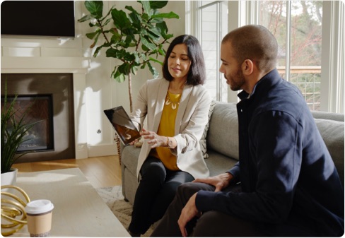 man and woman looking at tablet on couch